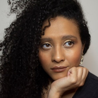 Headshot of AshSaidHi. She's got her head resting on her hand and she's kind of looking up and away.