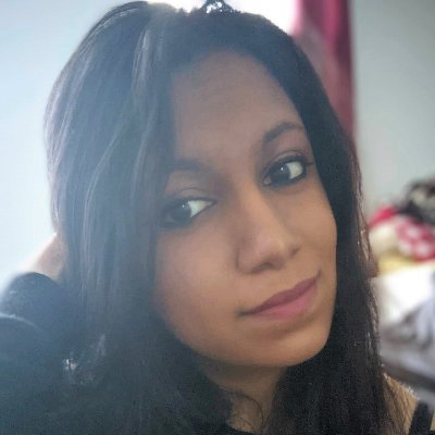 Headshot of Neha Patel. She is closed-mouth-smiling, and kind of side eyeing the camera with one hand behind her head. (Source: Twitter)